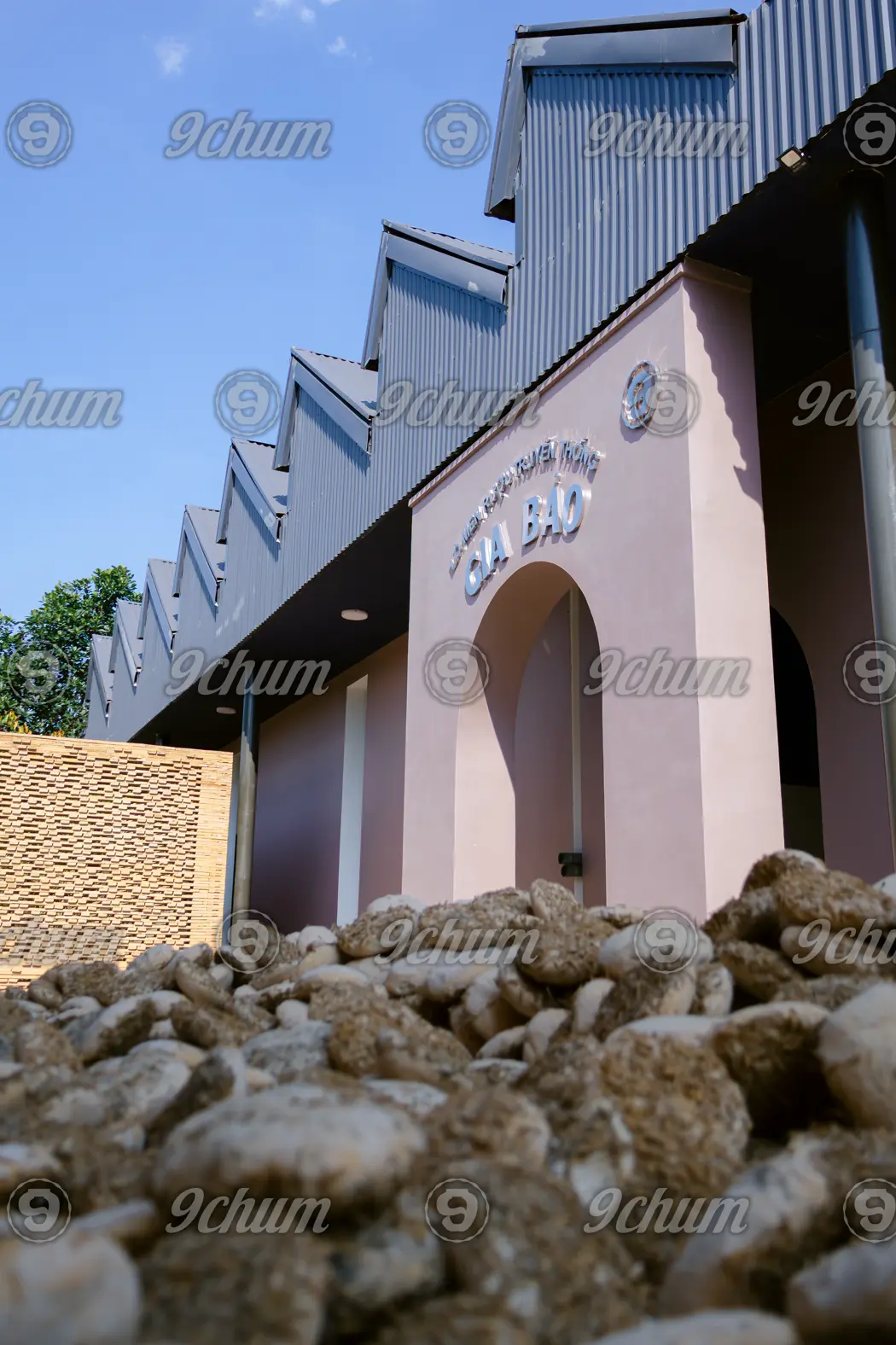 Cửa vòm nhà men riêng của 9 Chum, men lá phơi thành đống trước cửa