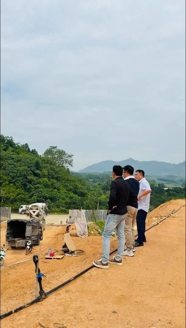Khánh cùng tổ đo đạc đứng bên máy khảo sát trên nền khu nhà máy thứ hai